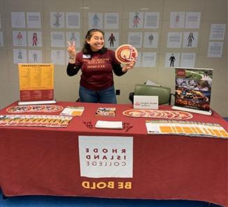 Alumni Admissions Ambassador standing at a materials table