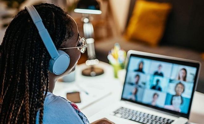 Woman at laptop on zoom call with nine people, bps