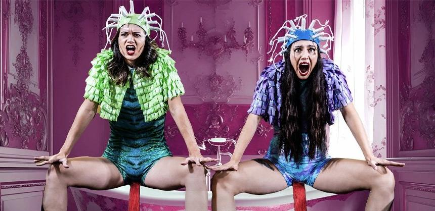 Two female performers sitting with screaming facial expressions